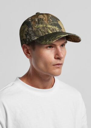 Model wearing camouflage baseball cap and white shirt, shown in profile against a gray backdrop.