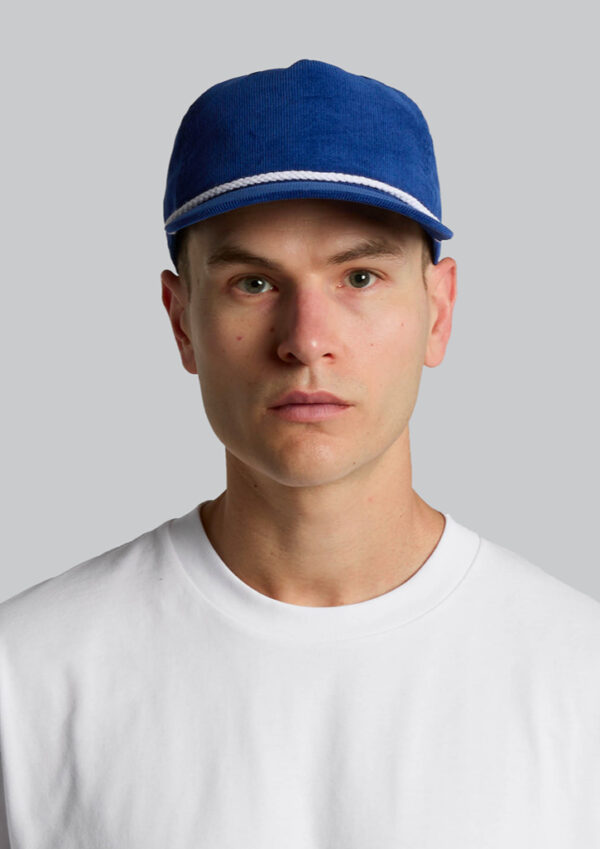 Portrait of a man wearing a blue cap with white trim and a white shirt, facing the camera against a gray background.