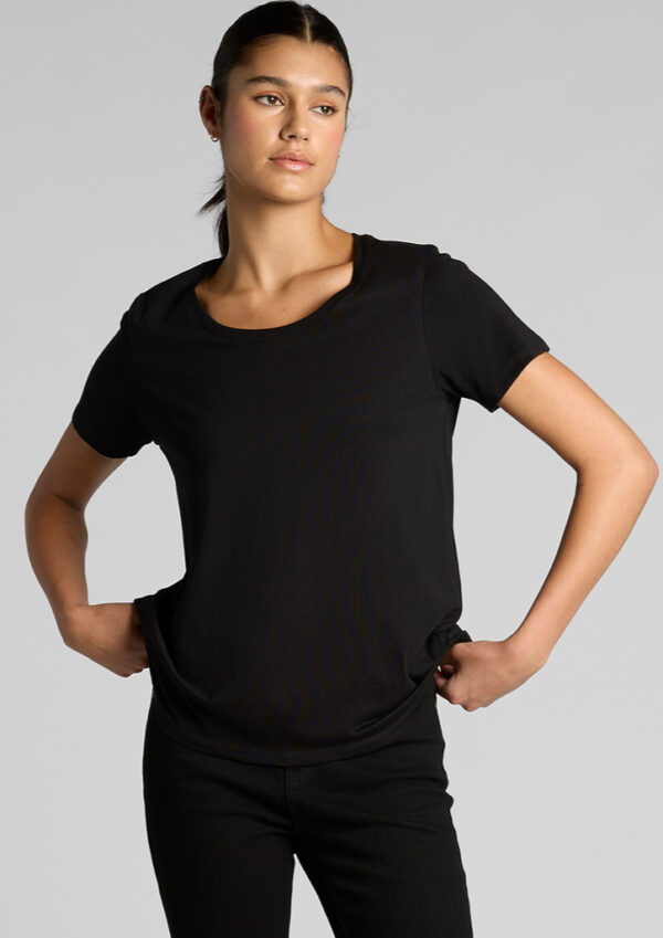 Model wearing a plain black short-sleeve t-shirt and black pants, standing with hands on hips against a light gray background.