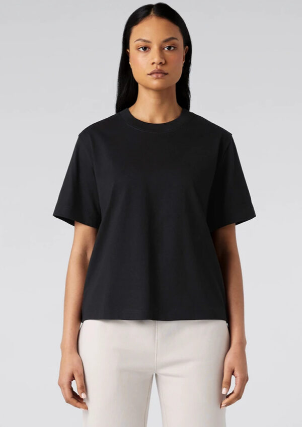 as4030_worn_00 Front view of a model wearing a black short-sleeve crew-neck T-shirt and light beige pants against a neutral gray background.