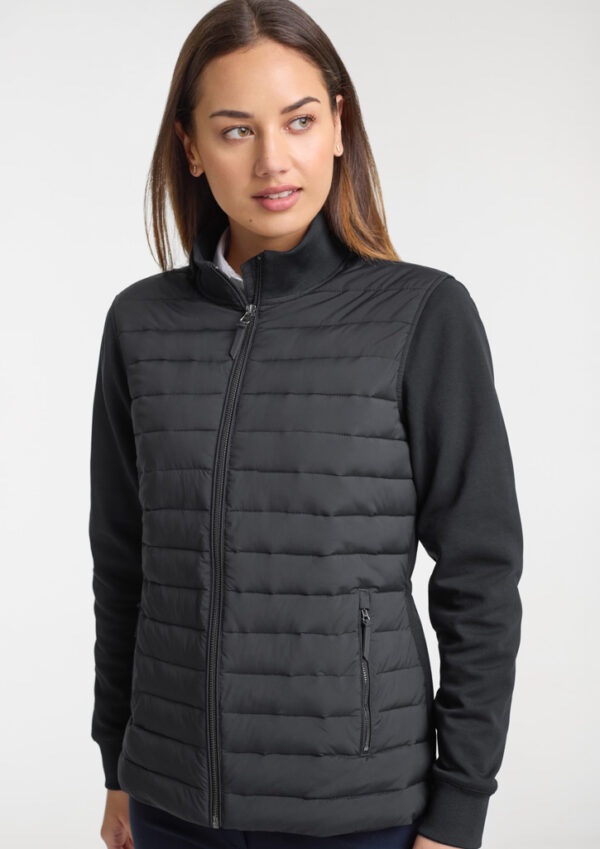 Woman wearing a black quilted zip-up jacket with a stand collar, looking to the side against a light background.