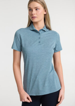 Woman wearing a light blue polo shirt with short sleeves, standing against a neutral background.