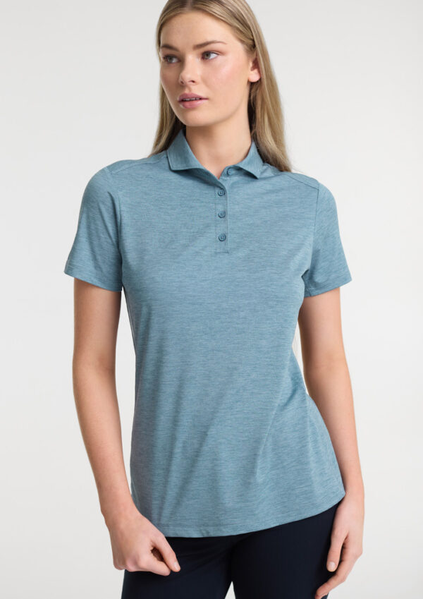 Woman wearing a light blue polo shirt with short sleeves, standing against a neutral background.