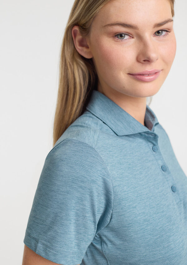 Portrait of a young woman with blonde hair wearing a light blue polo shirt, facing slightly to the side with a soft smile.