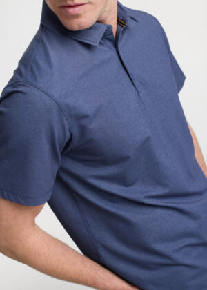 Man wearing a navy polo shirt from the chest up, showing collar and short sleeves in a studio shot