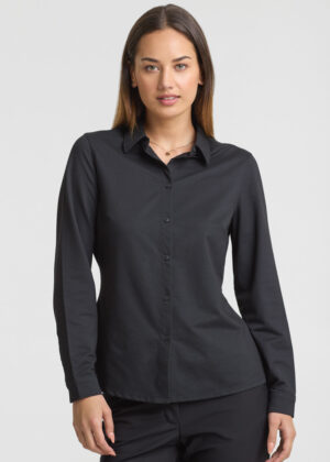 Woman in a black long-sleeve button-down shirt, standing against a pale background.