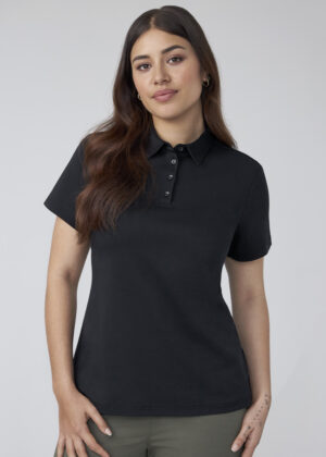Portrait of a woman wearing a black polo shirt with a buttoned collar, standing against a light gray background.