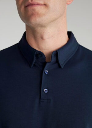 Close-up of a man’s neck and chin wearing a dark blue polo shirt with a buttoned collar.
