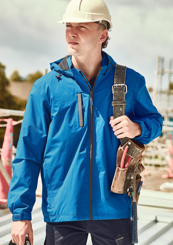 Construction worker in a white hard hat and blue jacket with a tool belt and pliers at a construction site on scaffolding