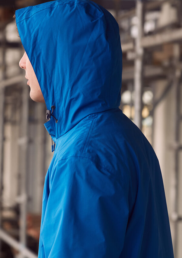 Person in a bright blue hooded jacket, seen in profile outdoors. The hood is up, partially obscuring the face.