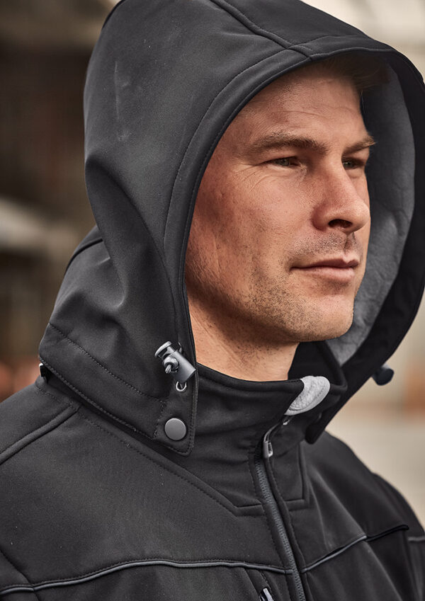 Man in a black hooded jacket, viewed in profile, looking to the right.