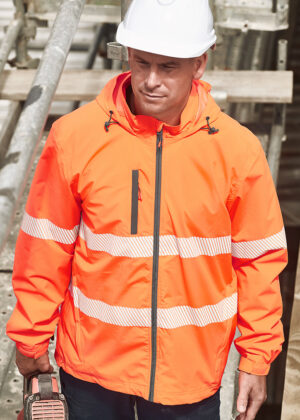 Construction worker wearing a bright orange high-visibility jacket and white hard hat at a construction site, looking down.