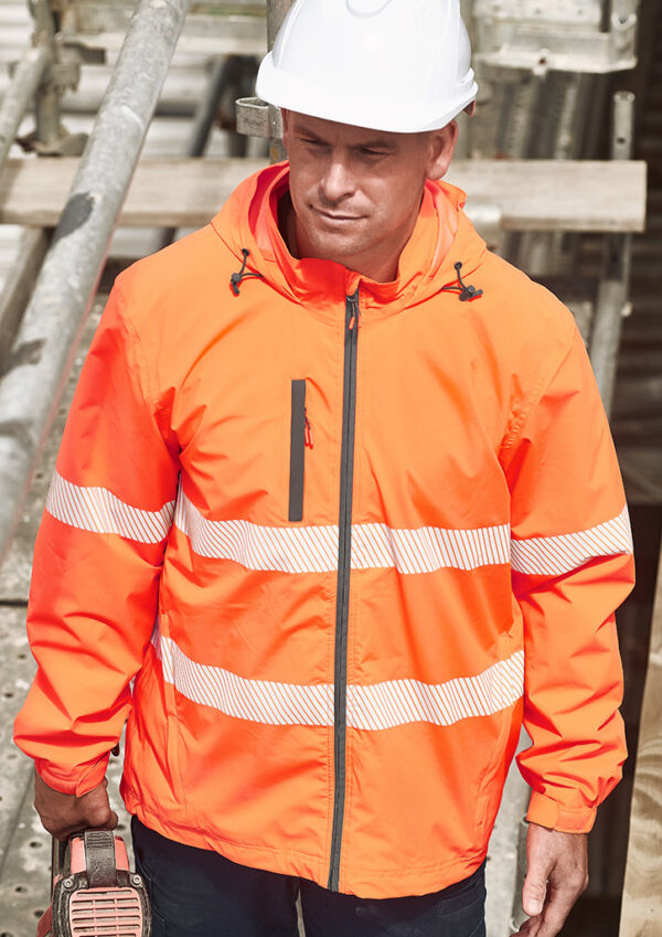 fbzj560_worn_01.jpg Construction worker wearing a bright orange high-visibility jacket and white hard hat at a construction site, looking down.