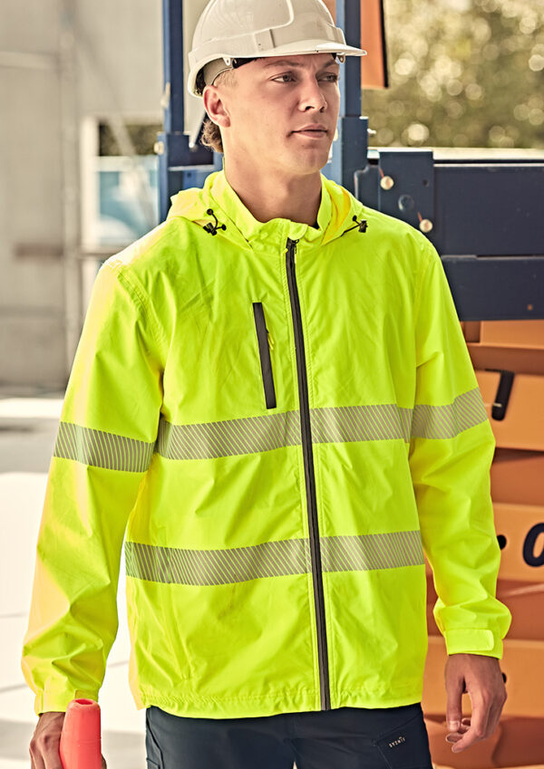 Construction worker wearing a neon-yellow high-visibility jacket and white hard hat on a site.