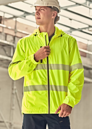 Construction worker in a neon yellow high-visibility jacket and white hard hat, looking to the left at a construction site.