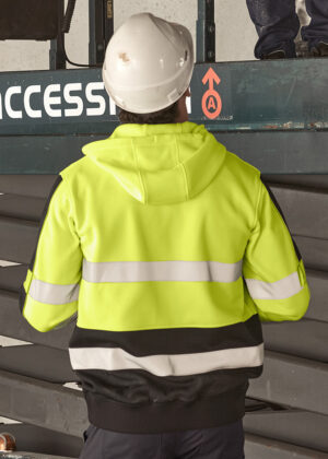 Construction worker in a neon safety jacket and white hard hat stands facing an access platform with a red safety symbol.