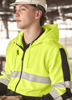 Construction worker in a neon safety jacket and white hard hat, looking to the left in an industrial setting