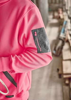Pink jacket sleeve with a gray zippered pocket and pink zipper detail.