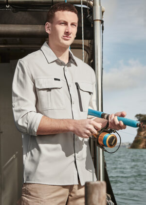 Man on a boat fishing, holding a blue fishing rod with a spinning reel by the water.